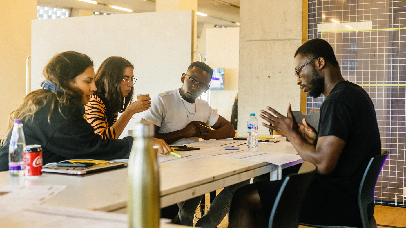 Rich talking through a worksheet with three participants around a table